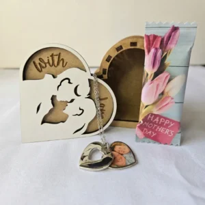 Personalised heart locket necklace with mother and child keepsake box on a table with flowers